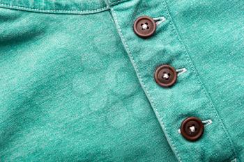 Closeup of green cloth with plastic buttons