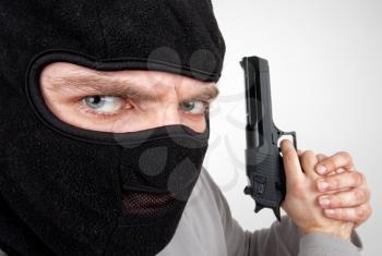 Close-up of serious armed criminal with gun