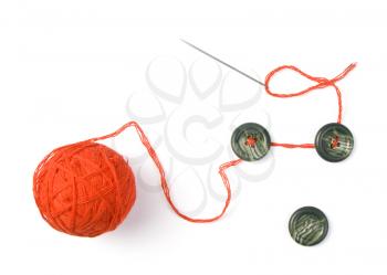 Sewing needle with red ball of threads and buttons