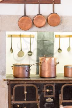Retro kitchen interior with old pans, pot on the furnace
