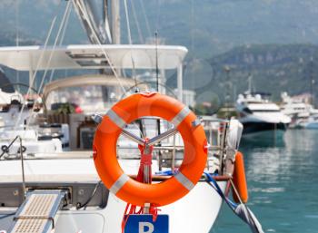 Lifebuoy in sea port against luxury yacht