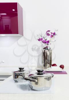 Nice white kitchen interior with orchid flower and saucepan