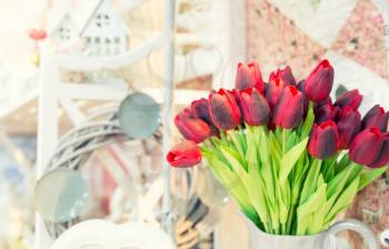 Vase of red tulips in modern  living room, closeup
