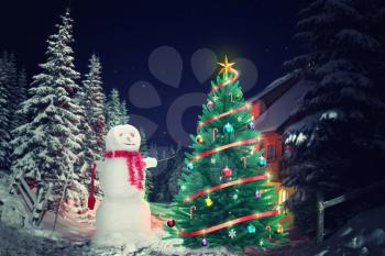Christmas tree and snowman outside in the evening