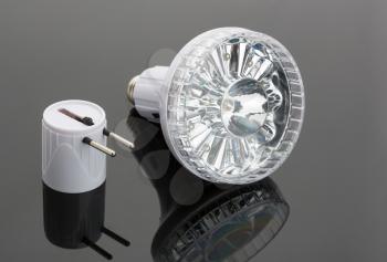 White modern flashlight with two-pin plug on the table