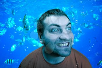 Surprised man under the water with fishes