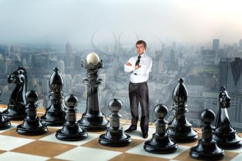 Businessman standing instead of king in the black team on the chess board 