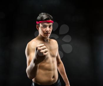  Young wrestle fighter standing over black background