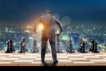 Businessman on the chess board ready to fight with black chess team