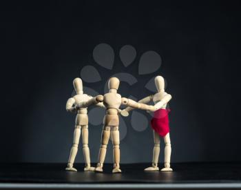 Family of wooden figures standing in circle over dark