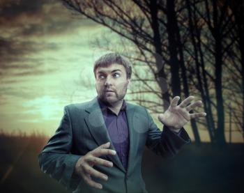 Scared businessman near the forest in the evening