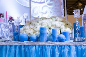 Wedding decorated hall with bouquet and blue candles