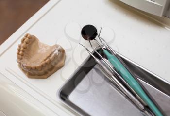 Dentist instruments and an artificial jaw on the table