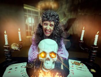 Sorceress practises witchcraft using the skull, its eyes are shining