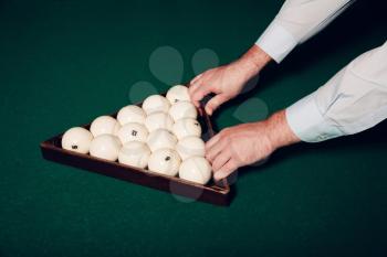 Close up of man's hands preparing billiard balls