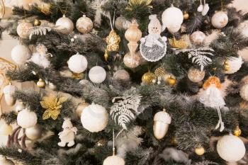 Closeup decorated christmas tree with white and gold toys on it. Merry xmas and new year concept. 