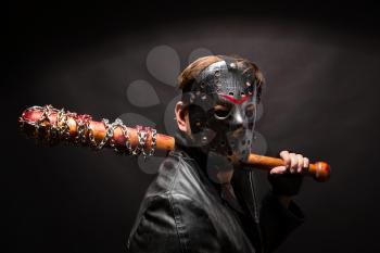 Bloody maniac in hockey mask and black leather coat with bat on black background