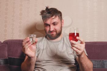 Alcohol addicted man choose drink for hangover after hard drinking.