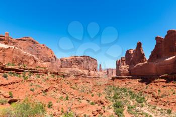 Mountains in valley against blue sky background. Landscape of Arches National Park.