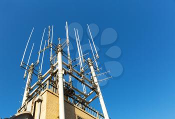 Closeup of telecommunication equipment on the building roof. Blue sky on the background.