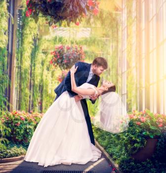 Beautiful newlyweds embrace in a green garden. Love couple walking