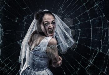 Screaming bride against cracked glass, black background