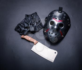 Crazy psycho man instruments isolated on black background. Hockey mask with bloody strips, fingerless leather gloves and meat cleaver. Serial murderer tools