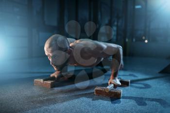 Healthy sportsman makes pushups exercises on training. Strong gymnast on workuot