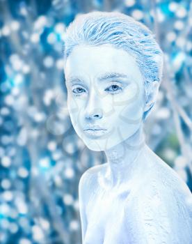 Attractive naked covered in ice woman with snowy winter forest on background. Sensuality  frosted girl. Snow frozen female, cold effect concept. Snow-covered makeup beauty