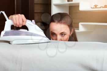 Young housewife work with steam iron. Housekeeping concept