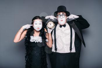 Pantomime actors performing with alarm clock. Comedy artist and actress waiting for bomb explosion. Mime theater performers 