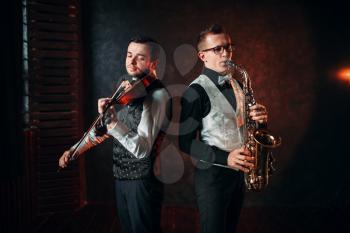 Saxophonist and violinst playing classical melody, musical duet. Jazz-man and fiddler
