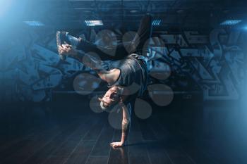 Breakdance action, dancer posing in dance studio. Modern urban dancing style
