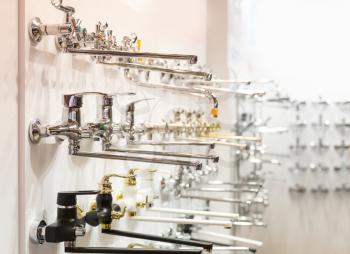 Rows of new faucets for bathroom in plumbing shop, closeup, nobody. Sanitary equipment