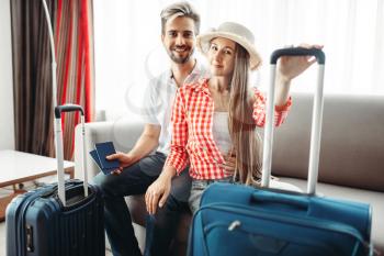 Happy couple with suitcases prepares for vacation. Fees on journey concept. Luggage preparation. Travelling or tourism