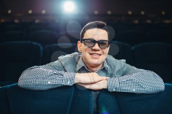 Young smiling man in 3d glasses watching the film in cinema. Showtime, entertainment industry
