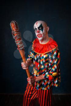 Crazy bloody clown with baseball bat. Man with makeup in halloween costume