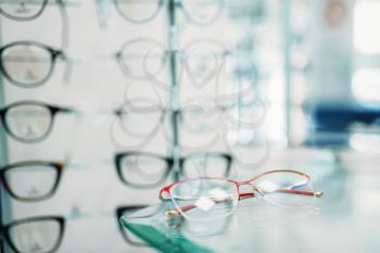 Glasses showcase in optic shop closeup, nobody. Eyes protection, eyeglasses on shelf in optical store, spectacles choice
