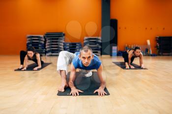 Stretching exercise, female yoga group, training with instructor, workout in gym. Yogi indoor