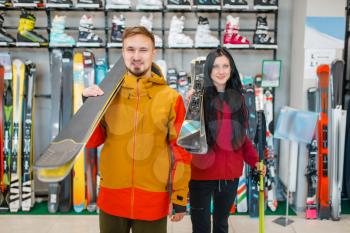 Couple with skis in hands, shopping in sports shop. Winter season extreme lifestyle, active leisure store, customers buying skiing equipment