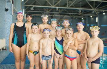 Group of children near a swimming pool. Healthy and happy childhood concept. Sportive kids activity in modern sport center.