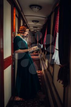 Young woman travels, vintage train compartment. Old wagon interior. Railway journey, railroad voyage