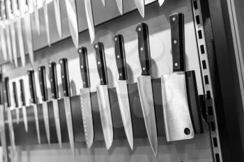 Kitchen knives collection on magnetic holder closeup. Cooking equipment