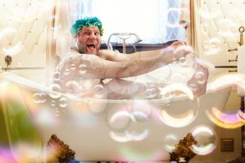 Fat ugly man washing in a bath. Bizarre male person laughing in bathroom