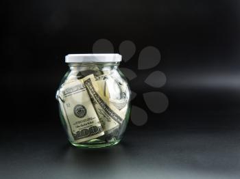 Money saving concept, glass jar full of dollars. Cash economy, home savings