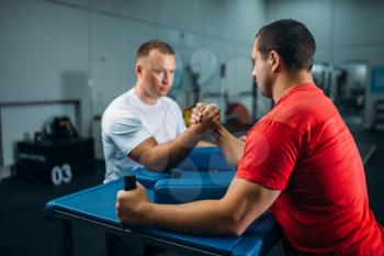 Two arm wrestlers at the table with pins, training before wrestling competition. Wrestle challenge, power sport