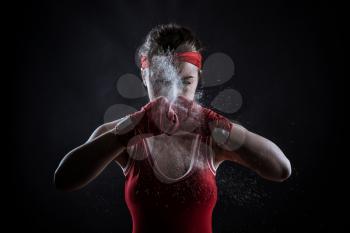 Female athlete in red boxing bandages and sportswear, front view. Fighting sport concept