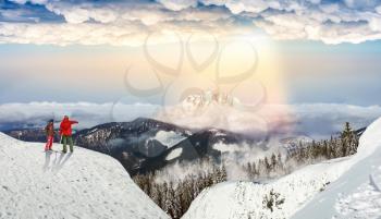 Downhill skiing, male and female skiers on the top of slope, blue sky and rainbow on background. Winter season active sport, extreme lifestyle