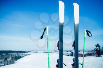 Skis and poles sticking out of the snow, nobody. Winter extreme sport concept. Mountain skiing equipment
