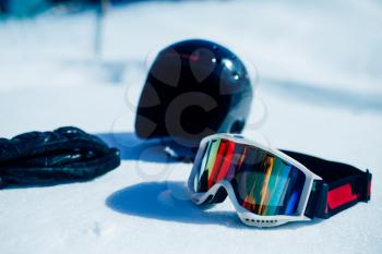 Helmet, glasses and gloves on the snow closeup, nobody. Winter extreme sport concept. Mountain skiing equipment